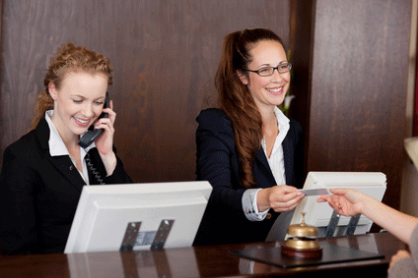 Bild zum Thema "Mitarbeiter-Coaching", 2 gepfelgte freundliche Mitarbeiterinnen am Empfang eines Hotels
