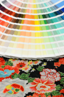 Foto zum Thema "Farb- und Stilberatung", Farbfächer, darunter ein bunter Stoff mit Blumendruck